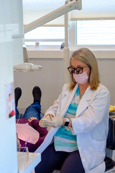 Dr. Lyn Fitzpatrick, DDS performing a restorative dentistry procedure on a patient